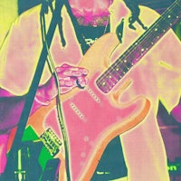 a man with dreadlocks holding a guitar