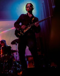 a man playing a guitar on stage